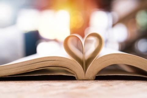 Open book with pages folded into a heart